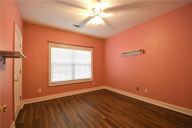 empty room with ceiling fan, dark wood-type flooring, and a textured ceiling