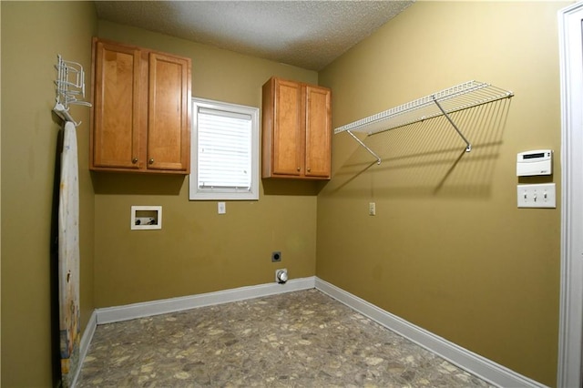 laundry room featuring hookup for an electric dryer, cabinets, a textured ceiling, and hookup for a washing machine