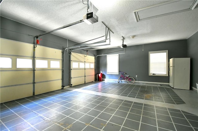 garage with a garage door opener and white refrigerator