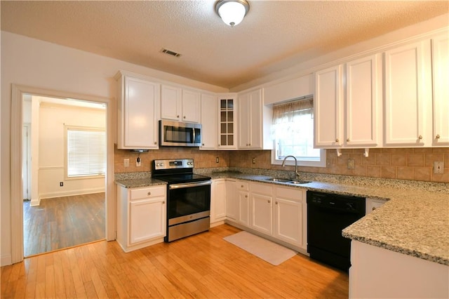 kitchen with white cabinets, stainless steel appliances, light hardwood / wood-style flooring, and sink