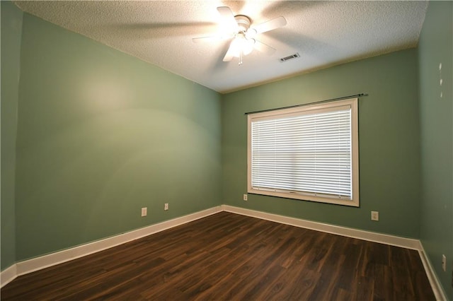 spare room with ceiling fan, a textured ceiling, and dark wood-type flooring