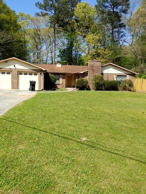 ranch-style home with a garage and a front lawn