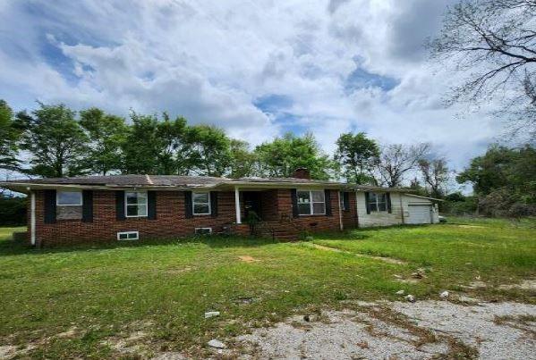 1705 Clifton St, Camden, AL 36726 - ranch-style house with a chimney, a front lawn, a garage, and brick siding