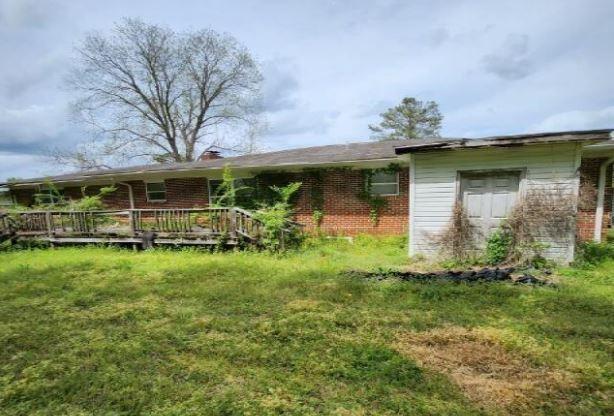 1705 Clifton St, Camden, AL 36726 - view of front of house with brick siding and a wooden deck