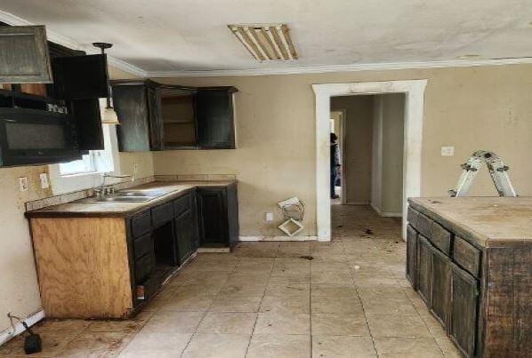 1705 Clifton St, Camden, AL 36726 - kitchen featuring a sink, ornamental molding, dark brown cabinetry, and baseboards