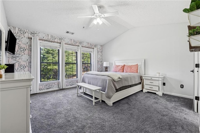 bedroom with vaulted ceiling, dark carpet, visible vents, and wallpapered walls