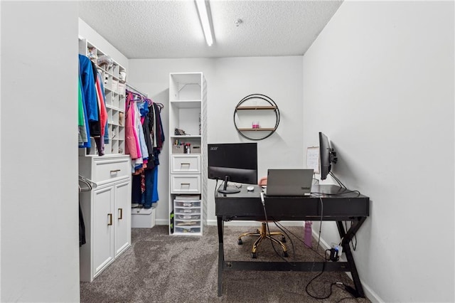 carpeted office space featuring a textured ceiling and baseboards