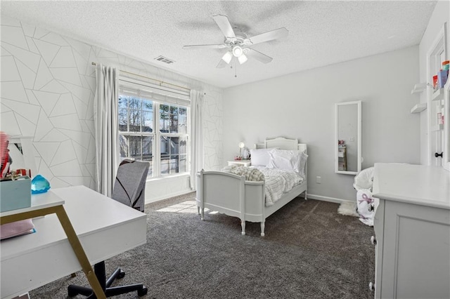 bedroom featuring dark colored carpet, visible vents, a ceiling fan, a textured ceiling, and baseboards