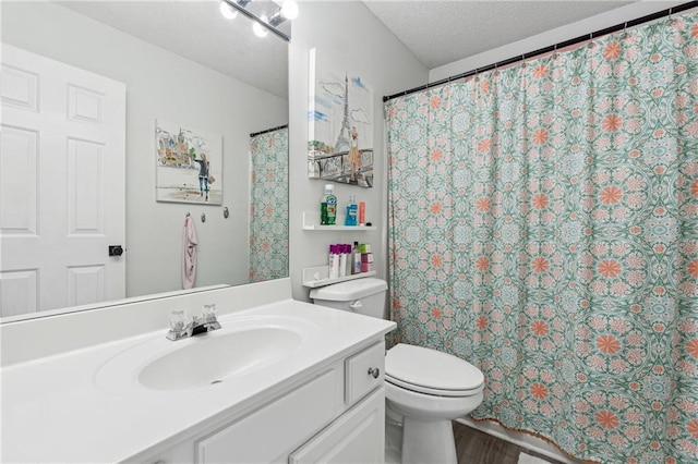 bathroom with curtained shower, toilet, vanity, a textured ceiling, and wood finished floors