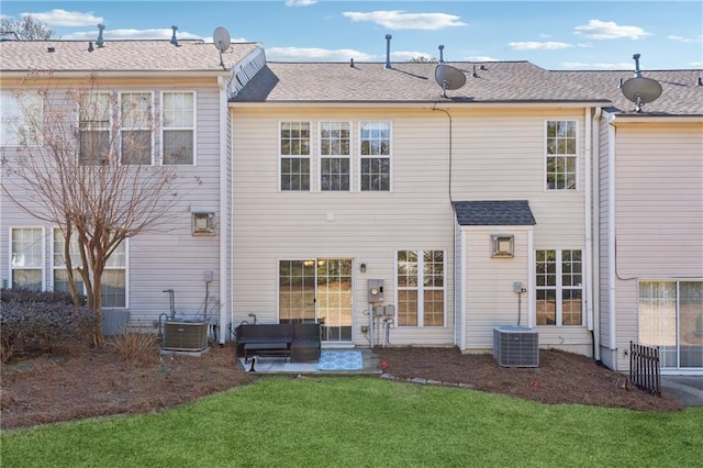 rear view of property with a yard and central AC