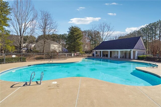 community pool featuring a patio and fence