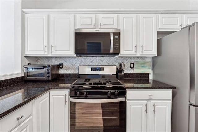 kitchen featuring stainless steel appliances, a toaster, white cabinetry, and decorative backsplash