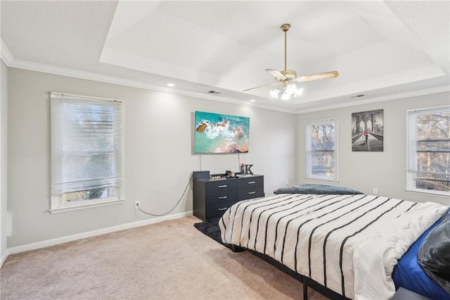 bedroom featuring crown molding, carpet flooring, a raised ceiling, and multiple windows