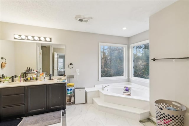 bathroom featuring a tub to relax in and vanity