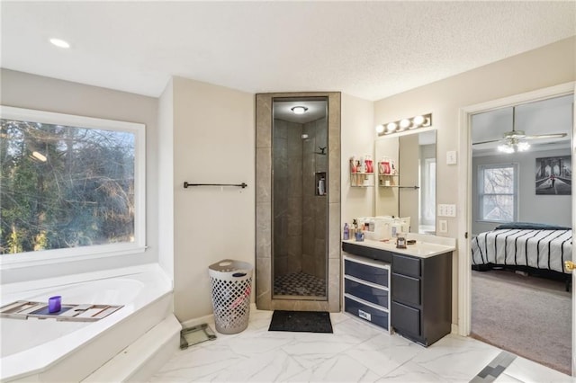 bathroom with vanity, ceiling fan, plus walk in shower, and a textured ceiling