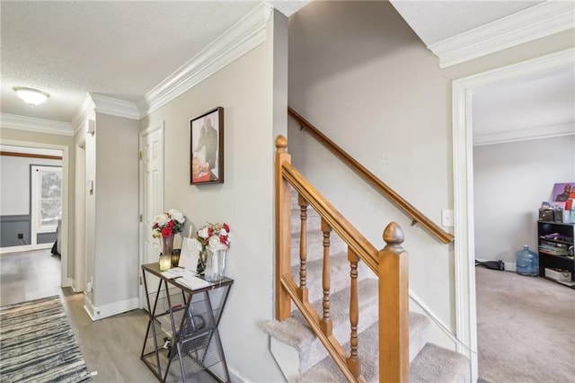 stairs with crown molding, hardwood / wood-style floors, and a textured ceiling