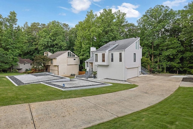 2683 Tritt Springs Trce NE, Marietta, GA 30062 - rear view of property with a garage, driveway, a lawn, roof with shingles, and a chimney