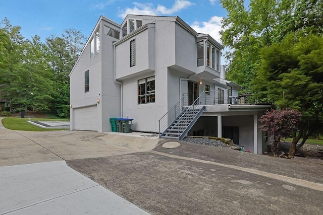 2683 Tritt Springs Trce NE, Marietta, GA 30062 - view of front facade featuring an attached garage, stairway, concrete driveway, and stucco siding