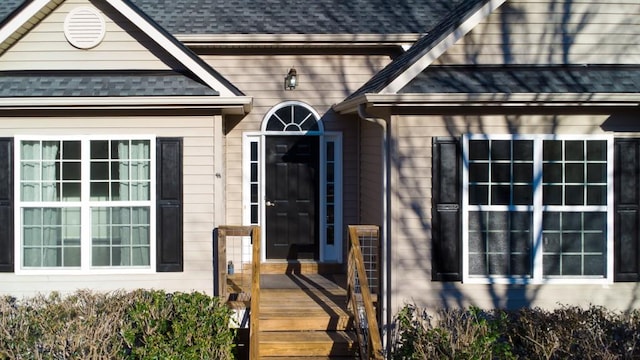 doorway to property featuring a shingled roof