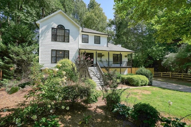 view of front of house featuring a front lawn, stairway, fence, and covered porch