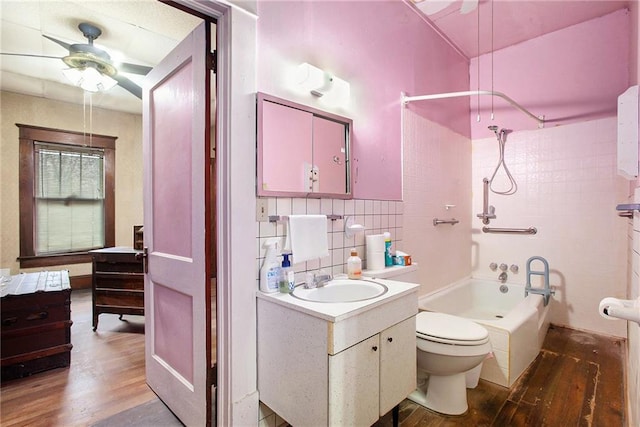 full bathroom featuring vanity, hardwood / wood-style flooring, tiled shower / bath combo, ceiling fan, and toilet