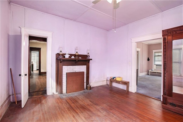 unfurnished living room with hardwood / wood-style flooring, a brick fireplace, and ceiling fan