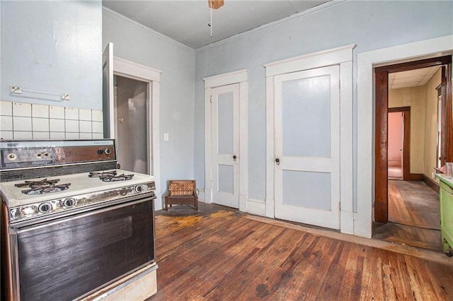 kitchen with ornamental molding, dark hardwood / wood-style flooring, ceiling fan, and white gas stove