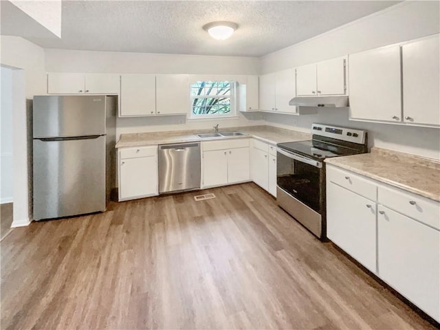 6354 Shannon Pkwy Unit 8B, Union City, GA 30291 - kitchen with stainless steel appliances, under cabinet range hood, light wood-type flooring, a textured ceiling, and light countertops