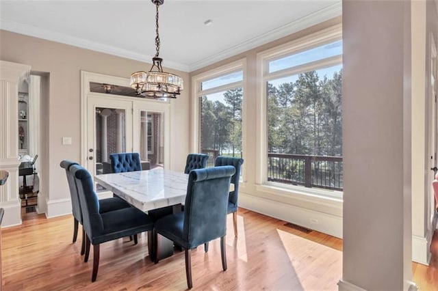 dining room featuring light wood-style floors, a chandelier, visible vents, and crown molding