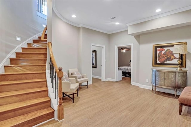 interior space with visible vents, baseboards, stairs, light wood-type flooring, and crown molding