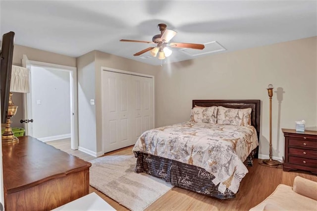 bedroom featuring baseboards, a ceiling fan, a closet, and wood finished floors