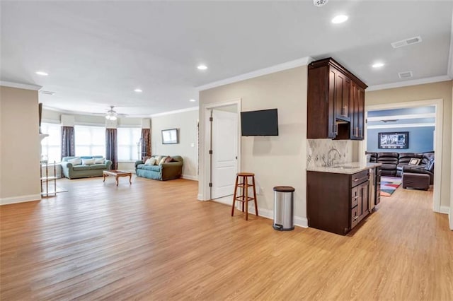 interior space featuring visible vents, open floor plan, and dark brown cabinets