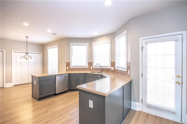 kitchen with kitchen peninsula, dishwasher, decorative light fixtures, gray cabinetry, and a notable chandelier