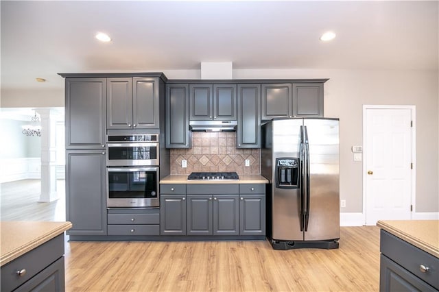 kitchen with tasteful backsplash, light hardwood / wood-style flooring, gray cabinetry, and appliances with stainless steel finishes