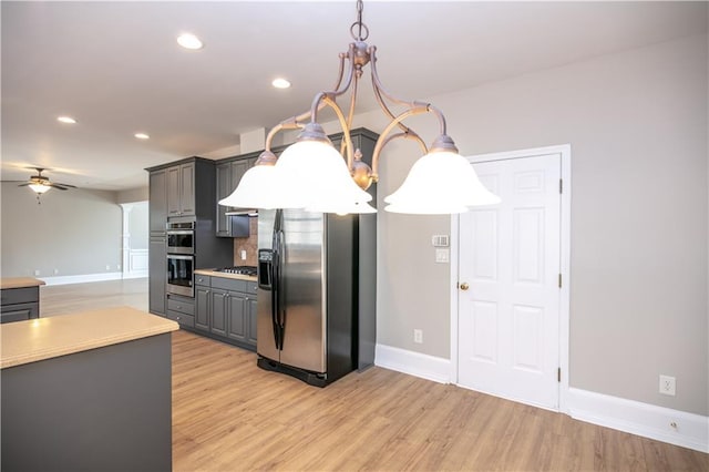 kitchen featuring ceiling fan, pendant lighting, light hardwood / wood-style flooring, and stainless steel appliances