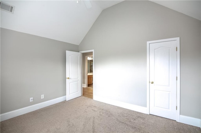 spare room with light carpet and high vaulted ceiling