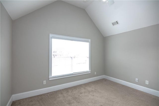 carpeted spare room with lofted ceiling