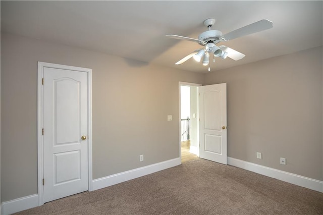 carpeted spare room with ceiling fan