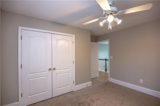 unfurnished bedroom with ceiling fan, light colored carpet, and a closet