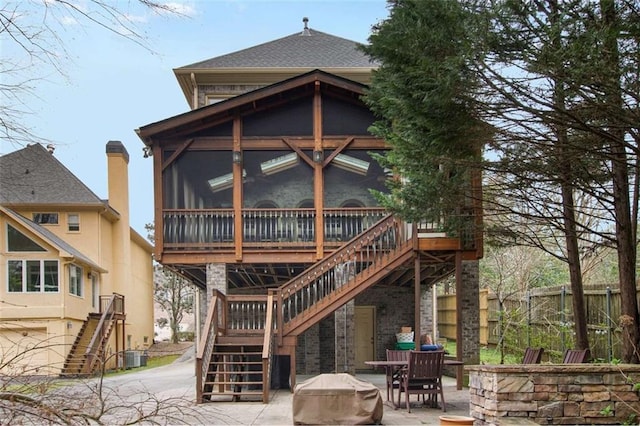 1109 Pine Grove Ave NE, Brookhaven, GA 30319 - back of property featuring stairs, a sunroom, fence, and a patio