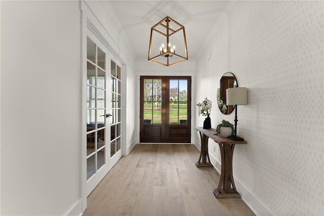 doorway to outside featuring french doors, baseboards, a chandelier, wallpapered walls, and hardwood / wood-style flooring