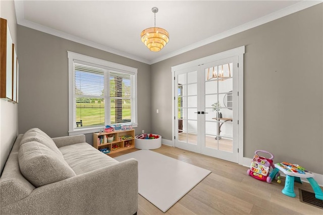 interior space with baseboards, ornamental molding, french doors, and light wood finished floors