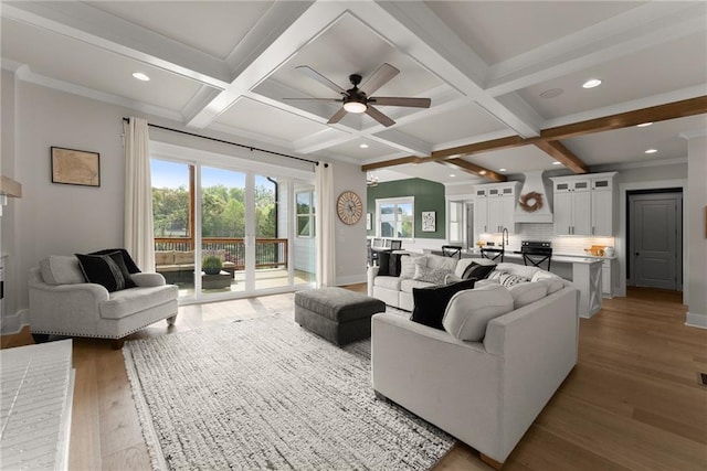 living area with light wood finished floors, baseboards, beam ceiling, and ceiling fan
