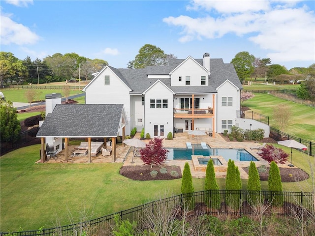 rear view of property featuring a yard, a patio, a fenced backyard, and a balcony