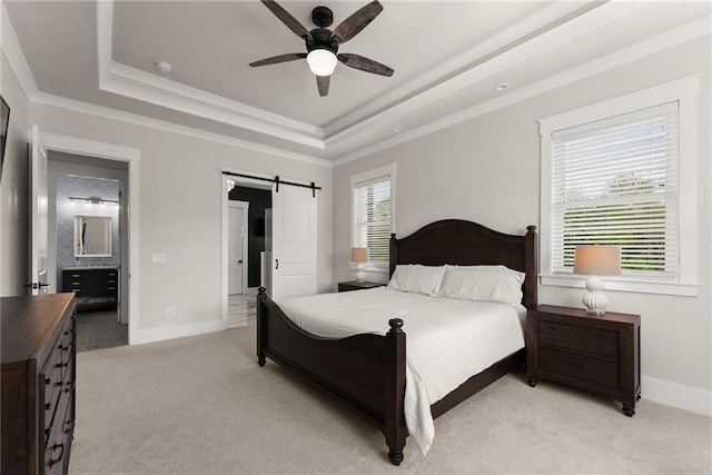 bedroom with light carpet, a raised ceiling, a barn door, baseboards, and ornamental molding
