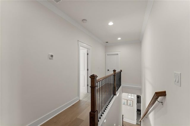 hallway with baseboards, recessed lighting, an upstairs landing, wood finished floors, and ornamental molding