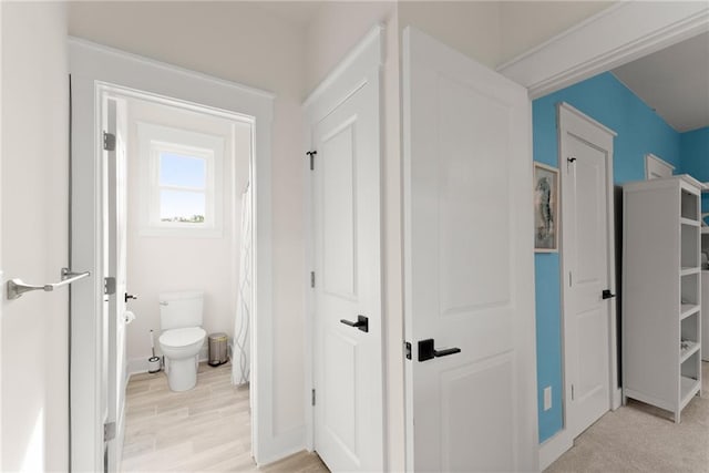 hallway featuring light wood-style floors and baseboards