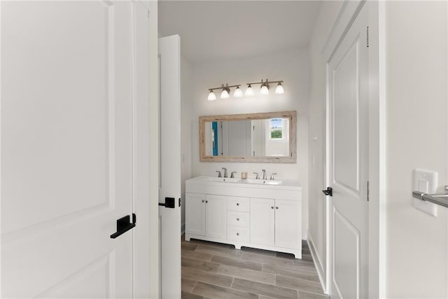 full bathroom featuring wood finished floors, a sink, and double vanity