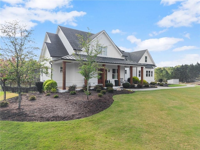 view of front of house featuring a standing seam roof, a front lawn, covered porch, and metal roof