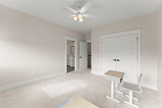 unfurnished office featuring carpet, a ceiling fan, and baseboards